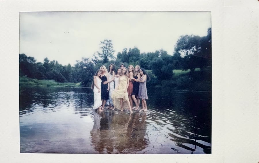 An instax print of that first group shoot — women standing together in a river at dusk