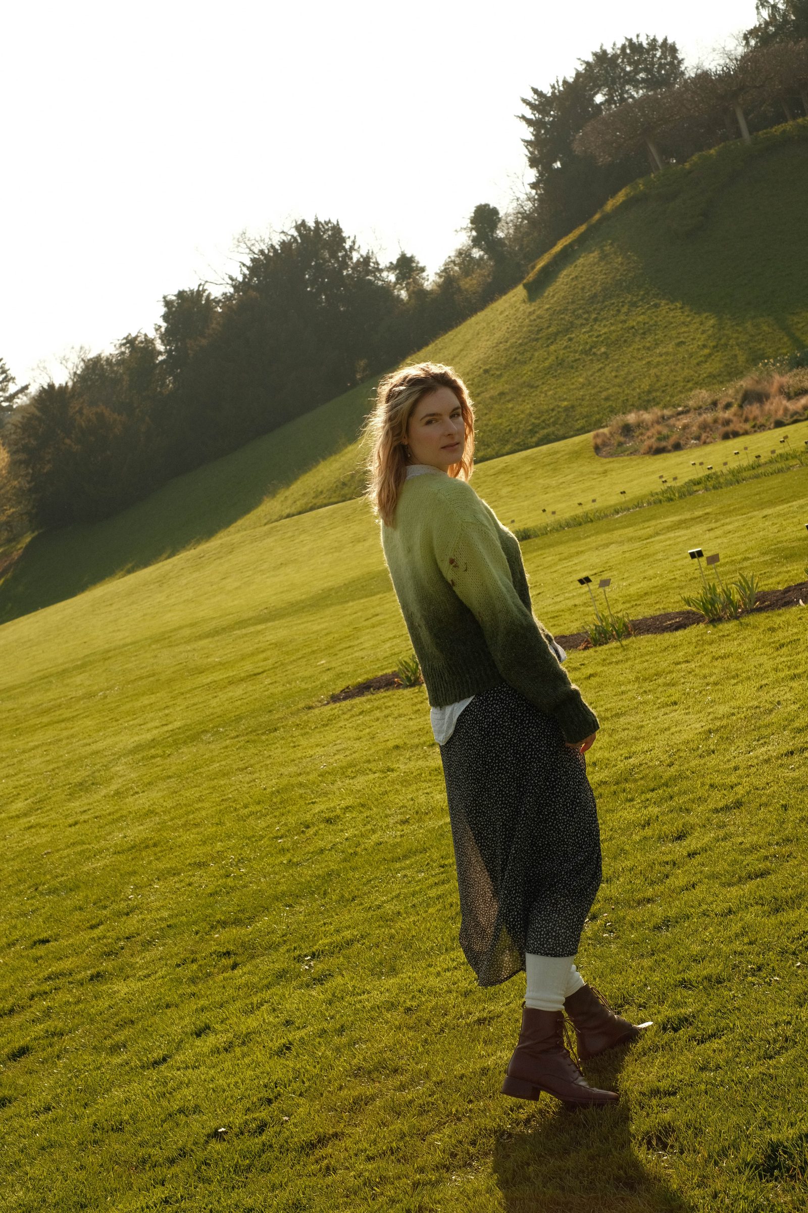 Woman standing on a green hillside