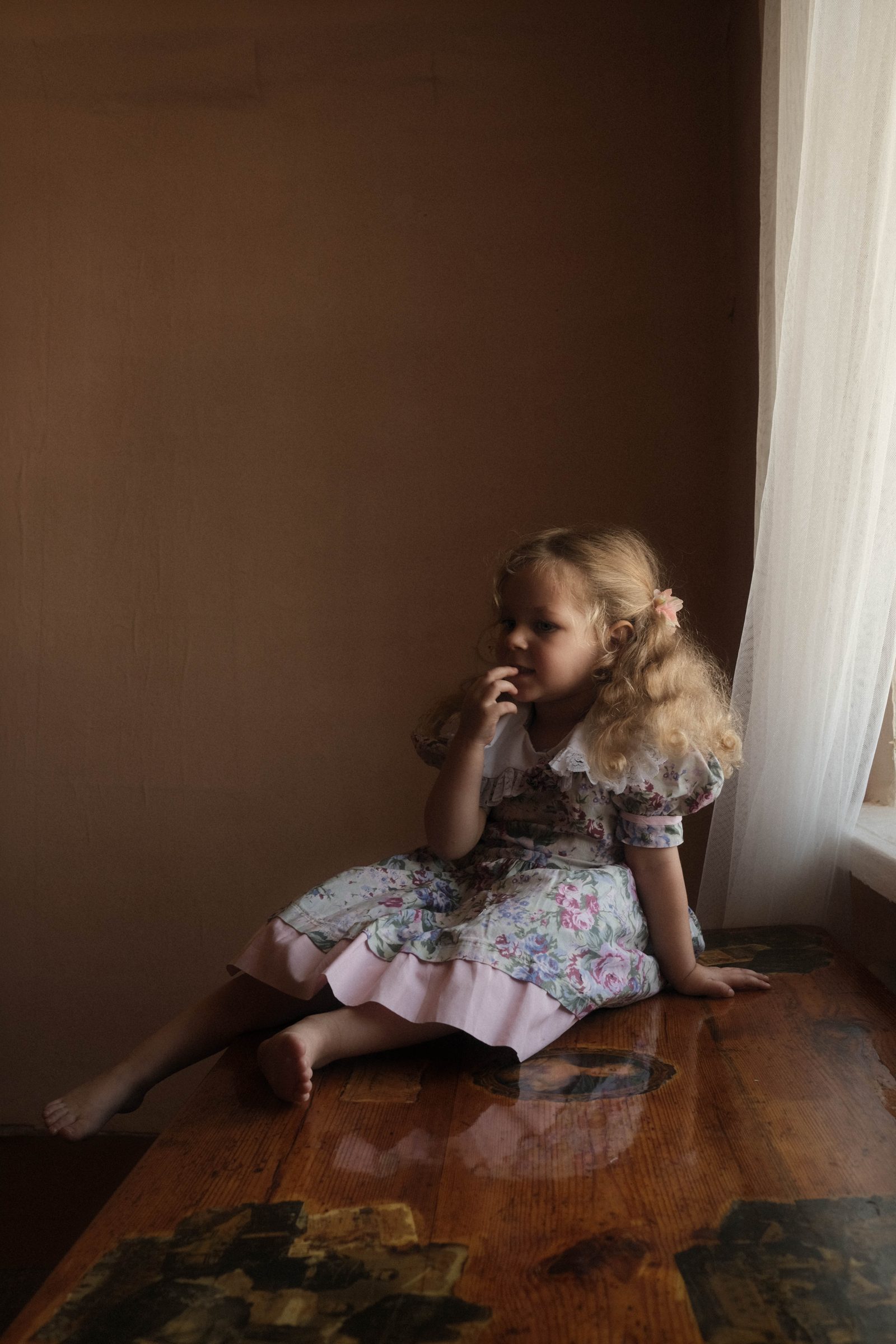 Child seated by a window