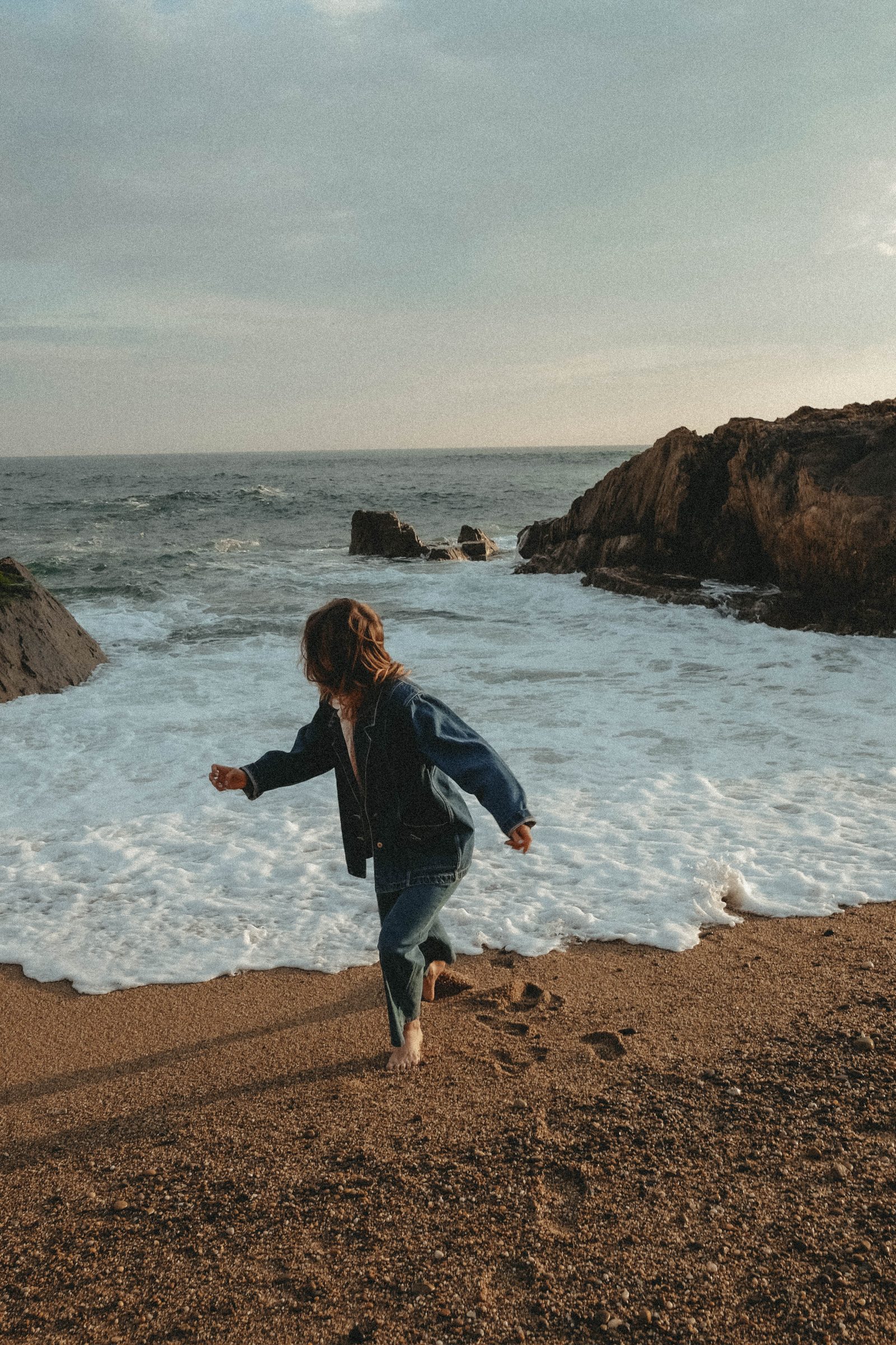 Child running along the shoreline