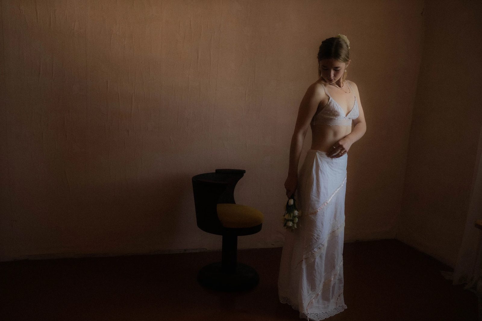 Woman in a white slip dress in a quiet interior