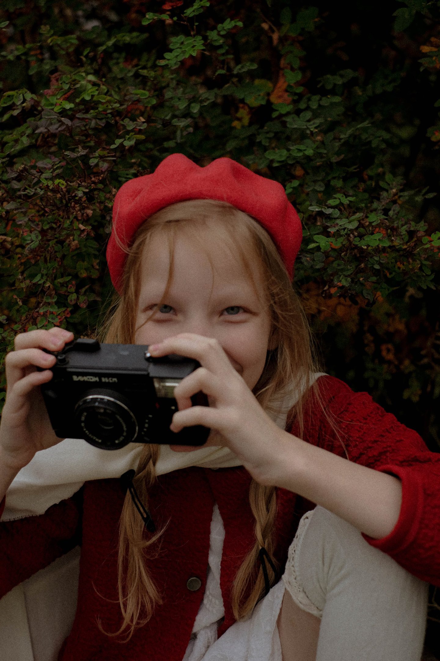 Girl in a red beret holding a camera